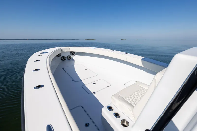 Slide: The Image of 2025 Conch 33 boat on calm water, featuring sleek white deck and seating. - 76