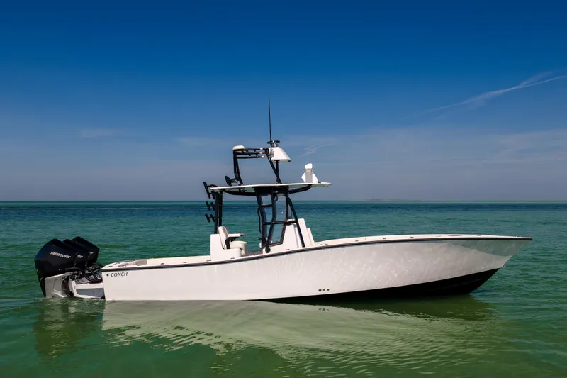 Slide: The Image of 2025 Conch 33 boat on calm turquoise water under clear blue sky. - 9