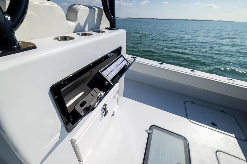 Slide: The Image of 2025 Conch 33 boat interior with open storage compartment on calm water. - 91
