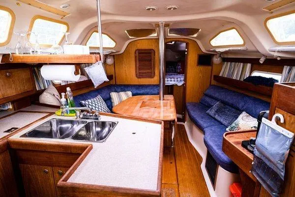 Slide: The Image of Interior of a 2001 Hunter 340 sailboat with cozy seating and kitchen area. - 13