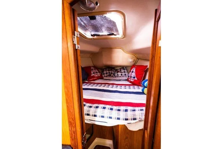 Slide: The Image of Cozy cabin interior of 2001 Hunter 340 sailboat with colorful bedding and wooden accents. - 19
