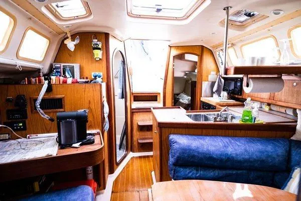 Slide: The Image of Interior of a 2001 Hunter 340 sailboat with wooden cabinetry and blue seating. - 22