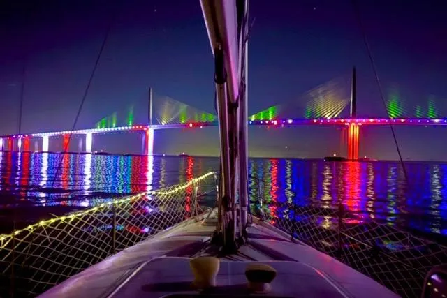Slide: The Image of Sailboat view of illuminated bridge at night, vibrant reflections on water. Hunter 340, 2001 model. - 31