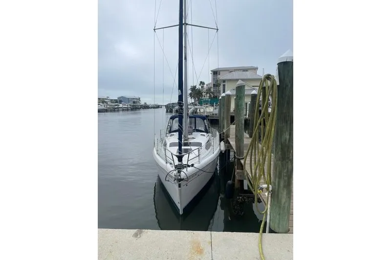 Slide: The Image of 2001 Hunter 340 sailboat docked at marina, overcast sky, calm water. - 35