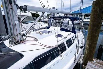Slide: The Image of 2001 Hunter 340 sailboat docked at marina with blue canopy and rigging. - 7