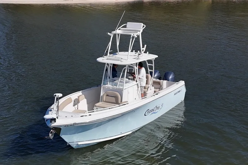 Slide: The Image of 2018 Sailfish 270 CC boat on calm water, featuring dual engines and sleek design. - 3