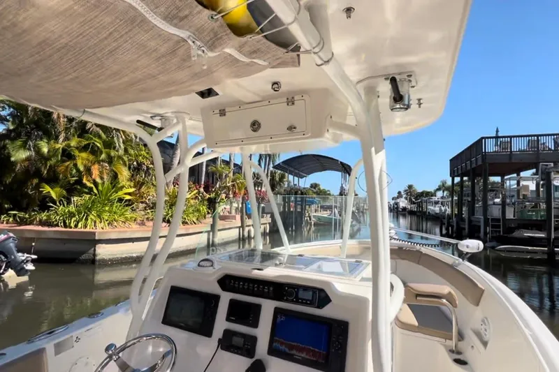 Slide: The Image of 2018 Sailfish 270 CC boat navigating a scenic canal with lush greenery. - 31
