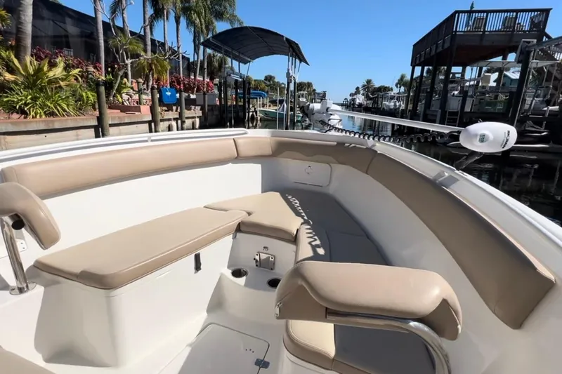 Slide: The Image of 2018 Sailfish 270 CC boat interior with beige seating, docked near palm trees. - 33