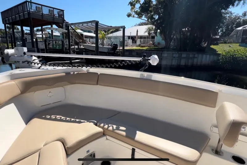 Slide: The Image of 2018 Sailfish 270 CC boat interior with beige seating and dockside view. - 35