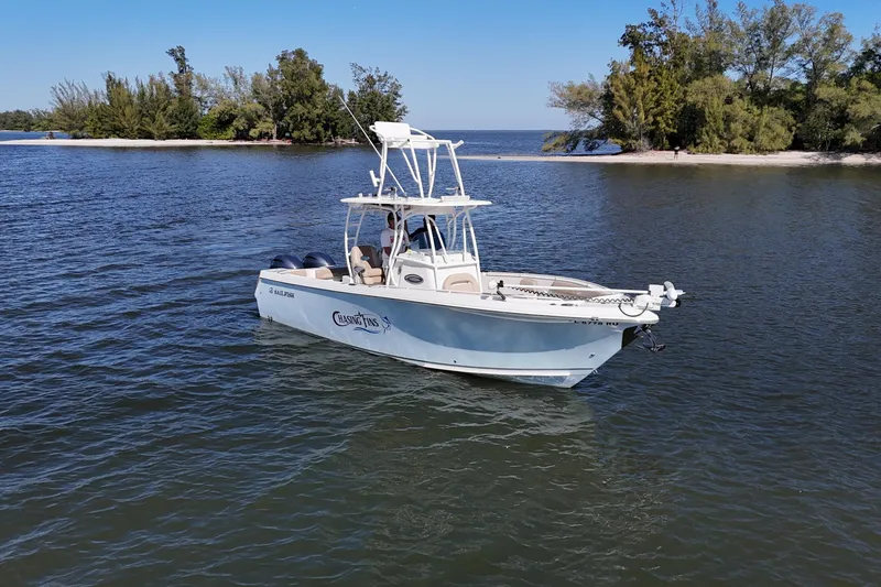 Slide: The Image of 2018 Sailfish 270 CC boat on calm water near a tree-lined shore. - 4