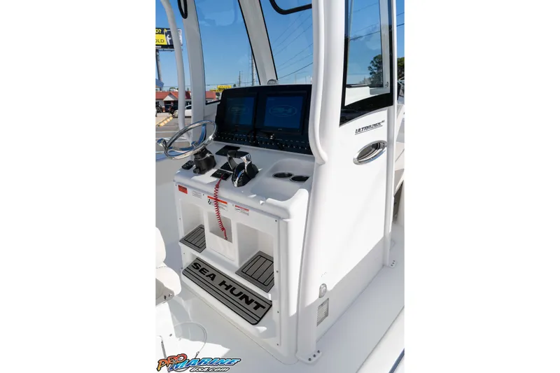Slide: The Image of 2026 Sea Hunt Ultra 265 SE boat console with steering wheel and controls. - 25