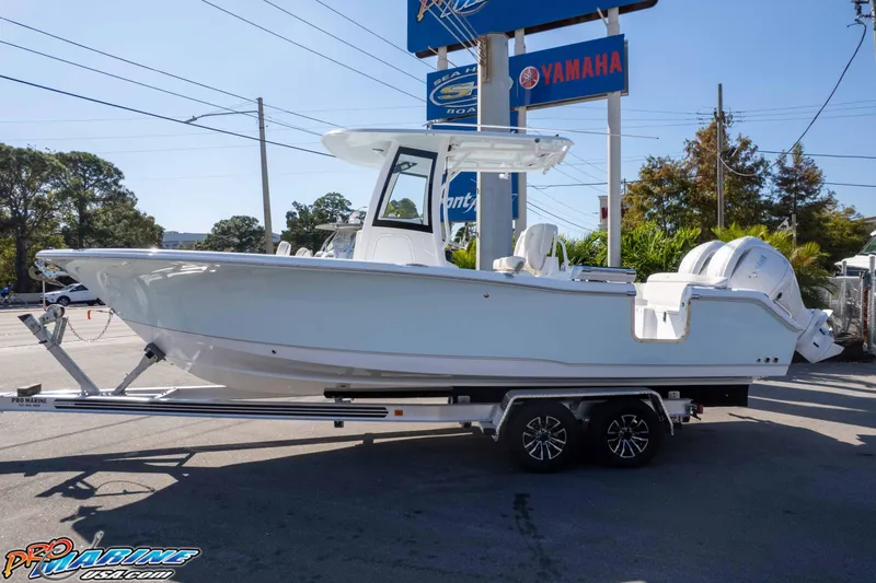 Slide: The Image of 2026 Sea Hunt Ultra 265 SE boat on trailer, displayed outdoors near dealership signs. - 5