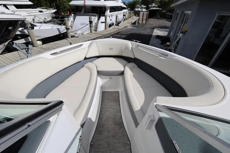 Slide: The Image of 2022 Cobalt 220S boat interior with white seating, docked at marina. - 14