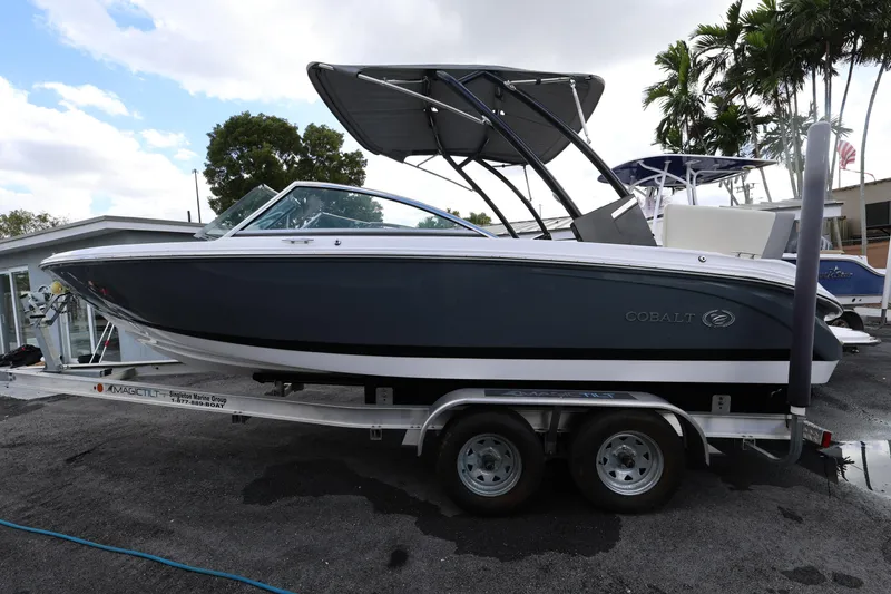 Slide: The Image of 2022 Cobalt 220S boat on trailer, parked outdoors under a cloudy sky. - 3