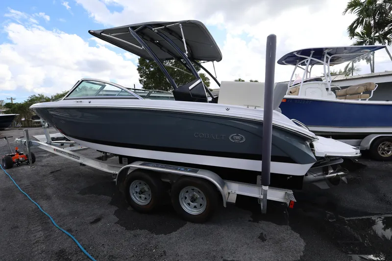 Slide: The Image of 2022 Cobalt 220S boat on trailer, parked outdoors under cloudy sky. - 4