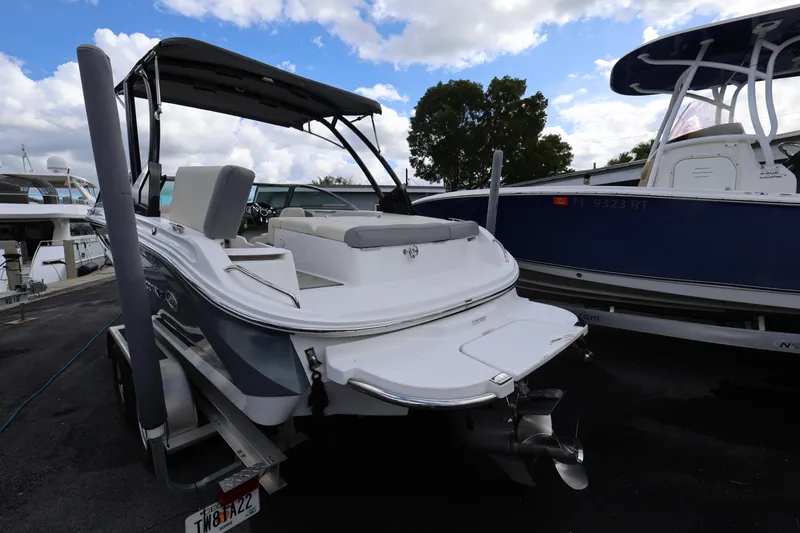 Slide: The Image of 2022 Cobalt 220S boat on trailer, docked with other boats, under a partly cloudy sky. - 5