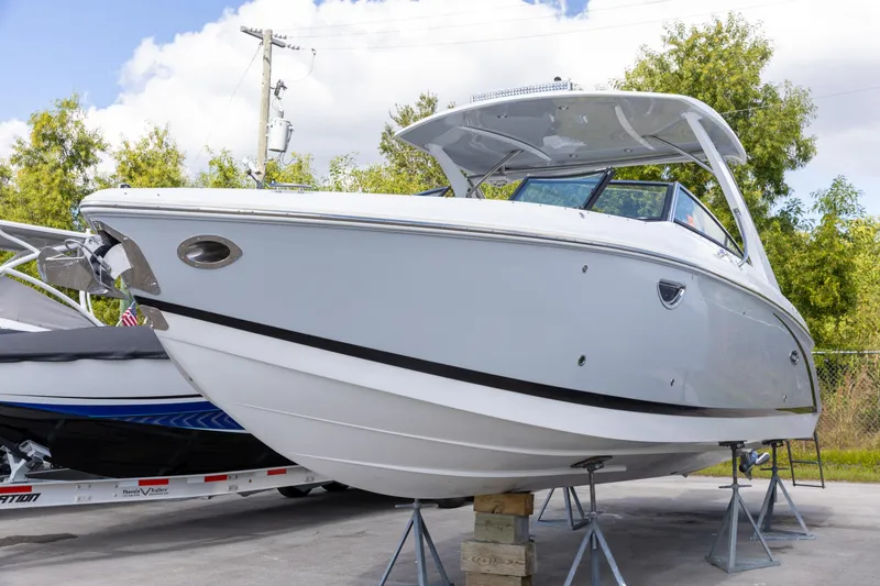 The Image of 2020 Cobalt 30SC Outboard boat on stands, displayed outdoors. - 0
