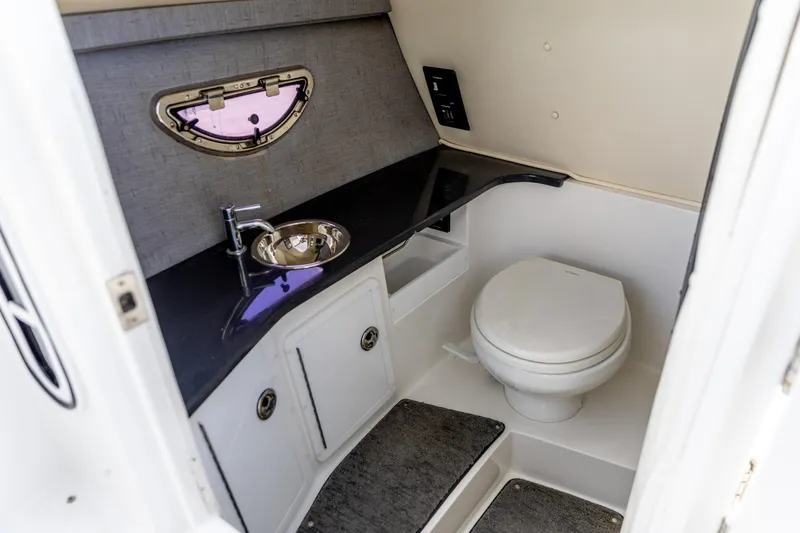 Slide: The Image of 2020 Cobalt 30SC Outboard boat interior bathroom with sink and toilet. - 21