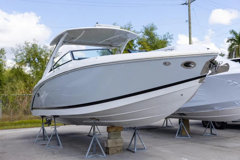 Slide: The Image of 2020 Cobalt 30SC Outboard boat on stands, displayed outdoors. - 7
