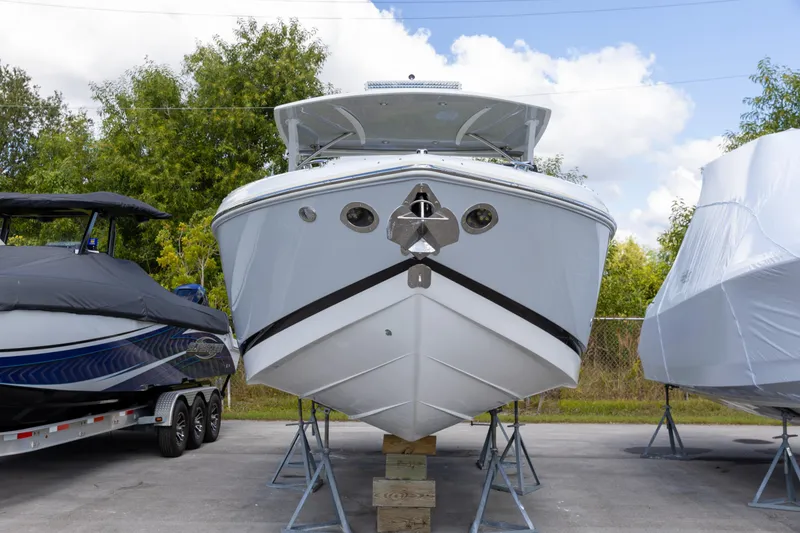 Slide: The Image of 2020 Cobalt 30SC Outboard boat on stands, surrounded by other covered boats. - 8