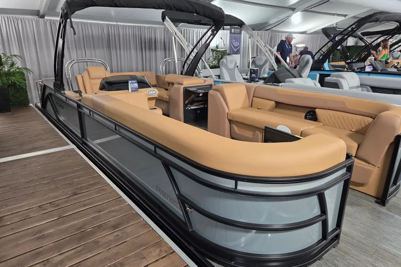 Slide: The Image of 2026 Godfrey SWEETWATER 2486 SFL pontoon boat with tan seating on display indoors. - 10