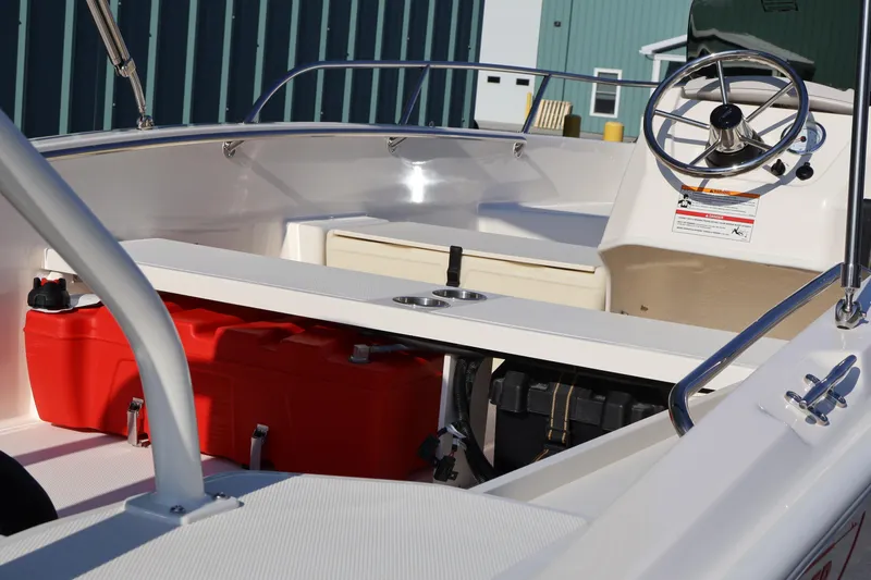Slide: The Image of 2026 Boston Whaler 160 Super Sport interior with steering wheel and red fuel tank. - 13