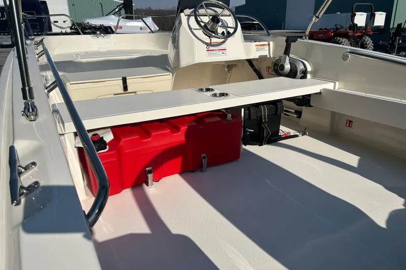 Slide: The Image of 2026 Boston Whaler 160 Super Sport interior with steering console and storage compartments. - 16