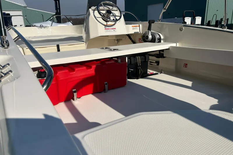 Slide: The Image of 2026 Boston Whaler 160 Super Sport interior with red storage compartment and steering console. - 7