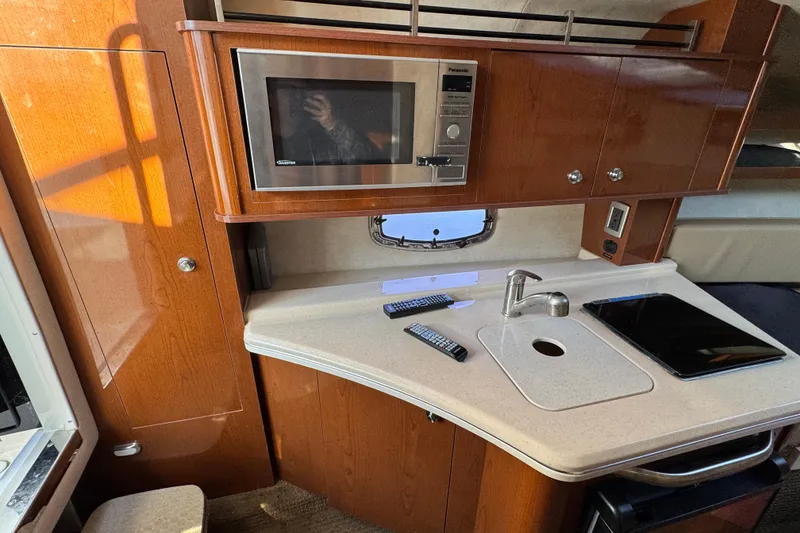 Slide: The Image of Interior of 2013 Sea Ray 280 Sundancer with kitchenette, microwave, and sink. - 19