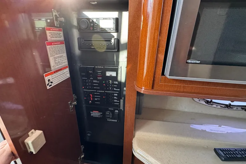 Slide: The Image of 2013 Sea Ray 280 Sundancer electrical panel and microwave in cabin interior. - 20