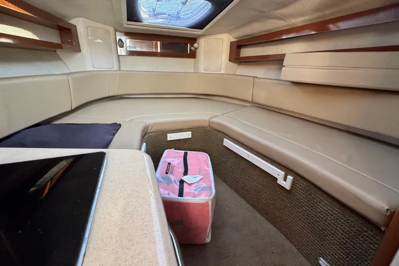 Slide: The Image of Interior of 2013 Sea Ray 280 Sundancer with beige seating and a pink storage bag. - 22