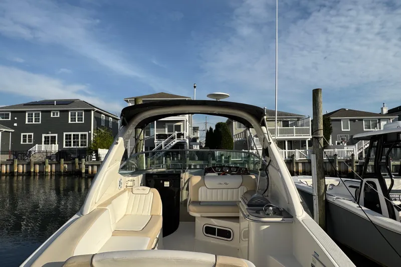 Slide: The Image of 2013 Sea Ray 280 Sundancer docked near waterfront homes under a clear sky. - 4