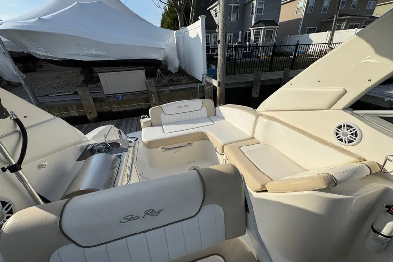 Slide: The Image of 2013 Sea Ray 280 Sundancer boat interior with seating and speaker, docked near houses. - 9