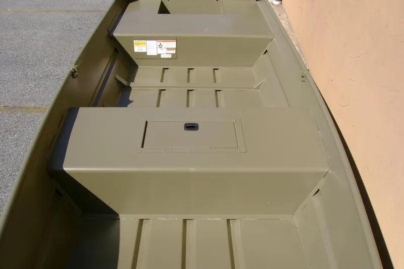 Slide: The Image of 2026 Tracker Grizzly 15 Jon boat interior with storage compartments, shown in a neutral color. - 7
