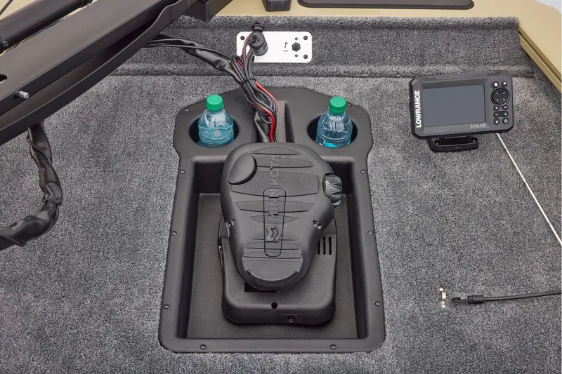 Slide: The Image of 2026 Tracker Pro Team 175 boat storage compartment with gray carpeted interior. - 16