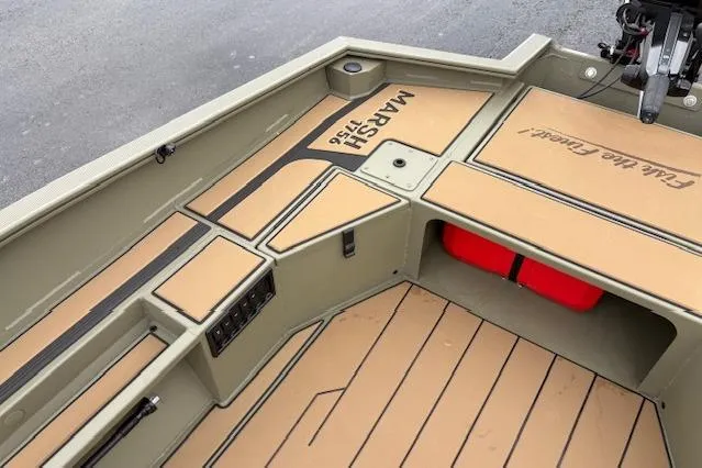 Slide: The Image of 2026 Tracker Grizzly 1756 T Marsh boat interior with tan deck and storage compartments. - 22