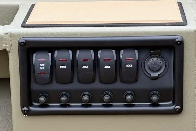 Slide: The Image of Control panel of 2026 Tracker Grizzly 1756 T Marsh boat with switches and 12V outlet. - 35