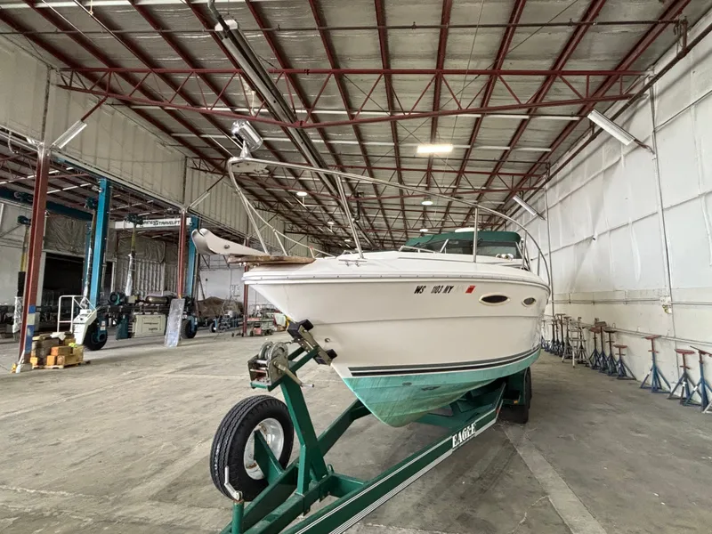 Slide: The Image of 1989 Sea Ray 290 Sundancer boat on trailer in spacious warehouse. - 5