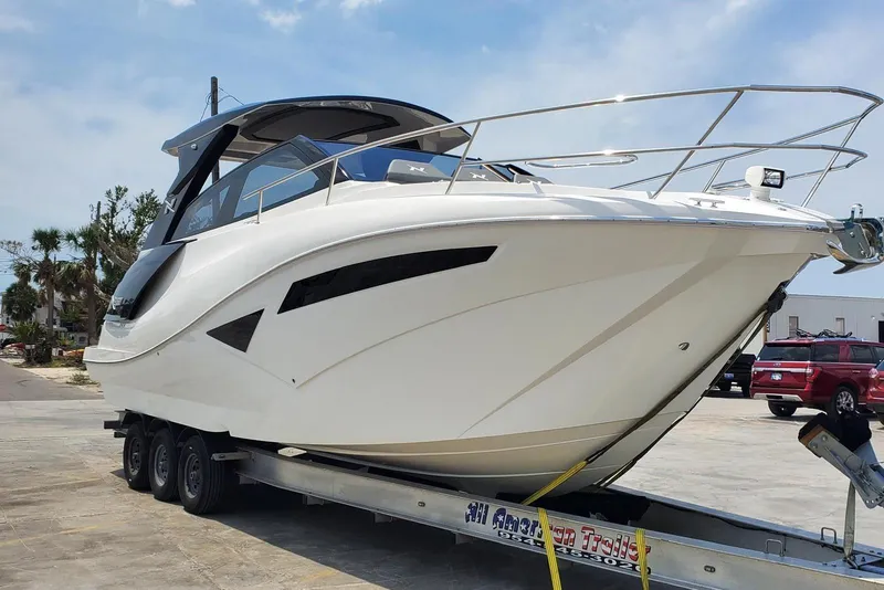 The Image of 2023 NX Boats NX360 on trailer, sleek design, parked outdoors. - 1