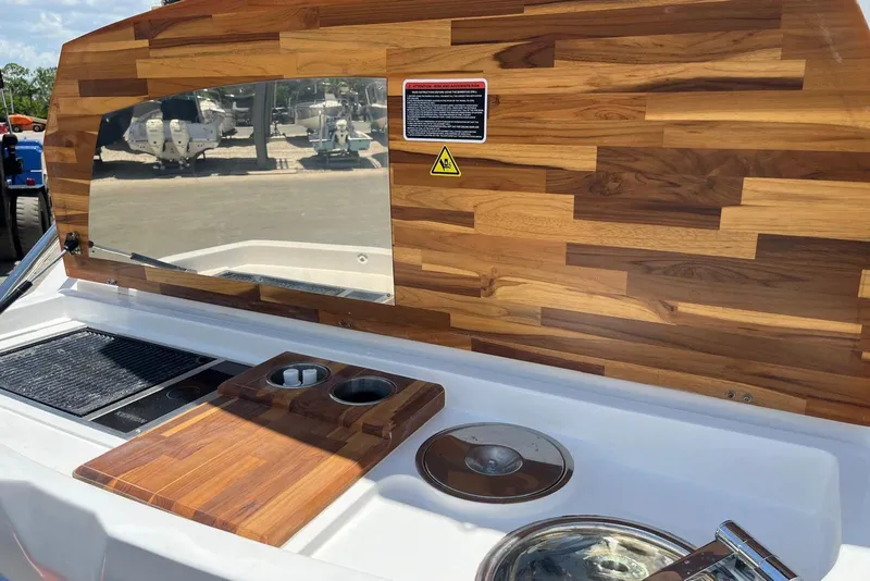 Slide: The Image of 2023 NX Boats NX360 interior with wooden paneling and built-in kitchen amenities. - 12