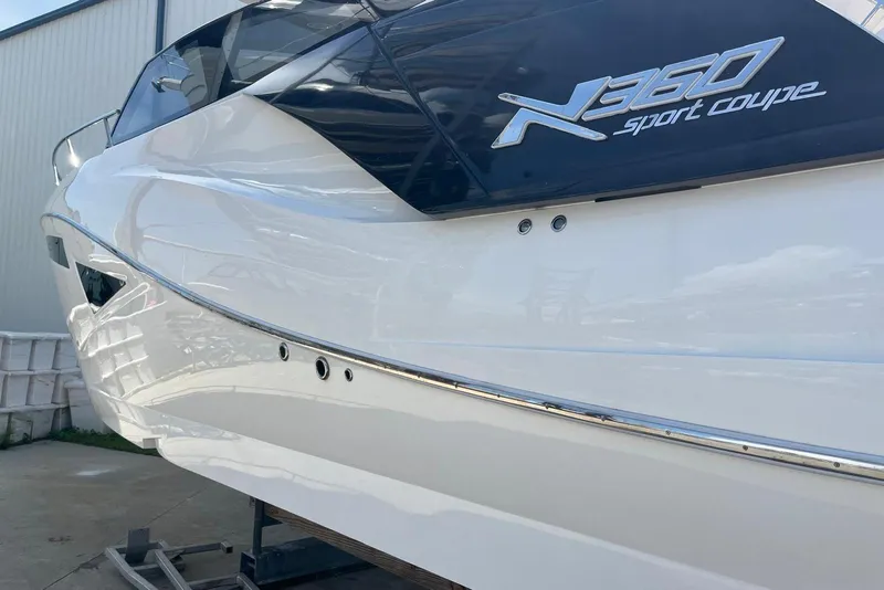 Slide: The Image of 2023 NX Boats NX360 Sport Coupe, sleek white exterior, docked at marina. - 4