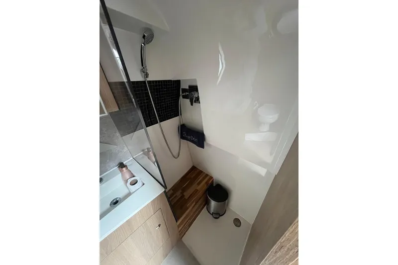 Slide: The Image of 2023 NX Boats NX360 bathroom with modern shower and wooden floor accents. - 5