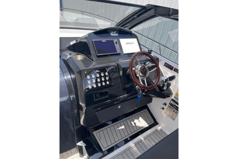 Slide: The Image of 2023 NX Boats NX360 helm with steering wheel and control panel. - 6