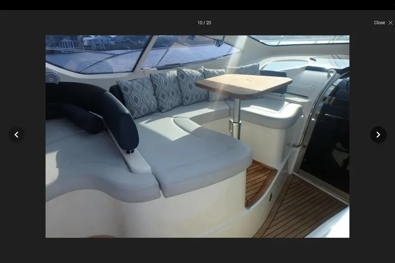 Slide: The Image of Interior of 2006 Azimut Atlantis 55 yacht with cushioned seating and wooden table. - 2
