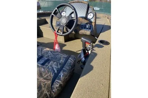 Slide: The Image of 2026 G3 Sportsman 1710 PFX boat storage compartments with camouflage seating. - 5