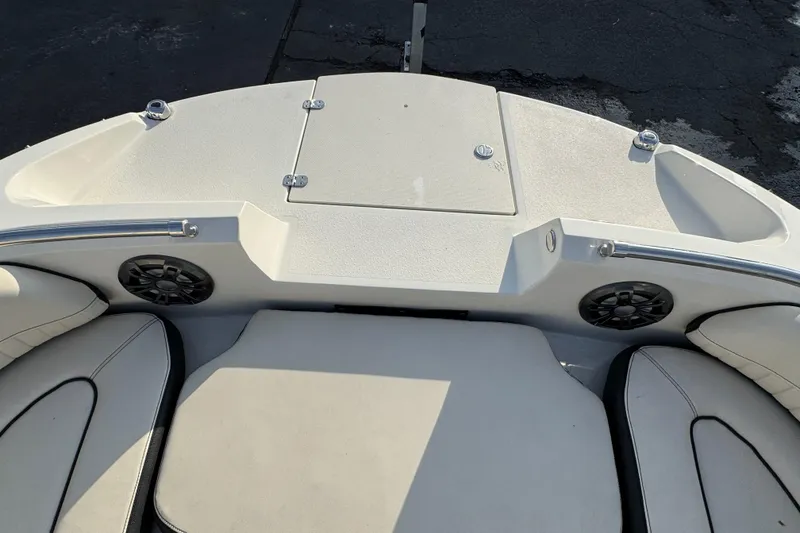Slide: The Image of 2021 Stingray 201 DC boat interior with cushioned seating and built-in speakers. - 13
