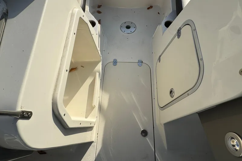 Slide: The Image of 2021 Stingray 201 DC boat interior with storage compartments and clean deck. - 16