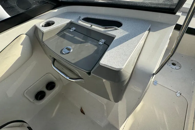 Slide: The Image of Interior of 2021 Stingray 201 DC boat featuring storage compartment and cup holders. - 17
