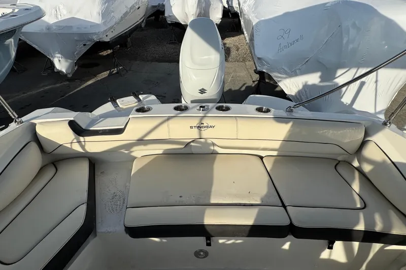 Slide: The Image of 2021 Stingray 201 DC boat interior with cushioned seating and cup holders. - 4