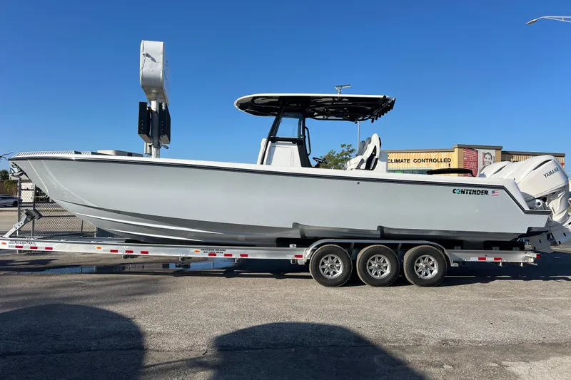 Slide: The Image of 2026 Contender 35 ST boat on trailer, featuring sleek design and triple-axle support. - 2